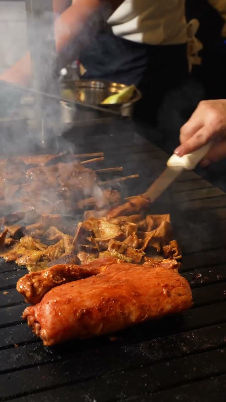 Pincelando la salsa anticuchera sobre los palos en la parrilla