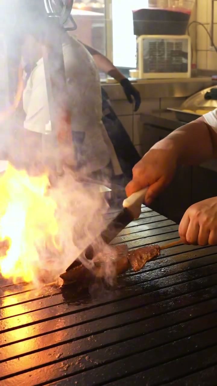 Anticuchos sobre las brasas con la llama viva