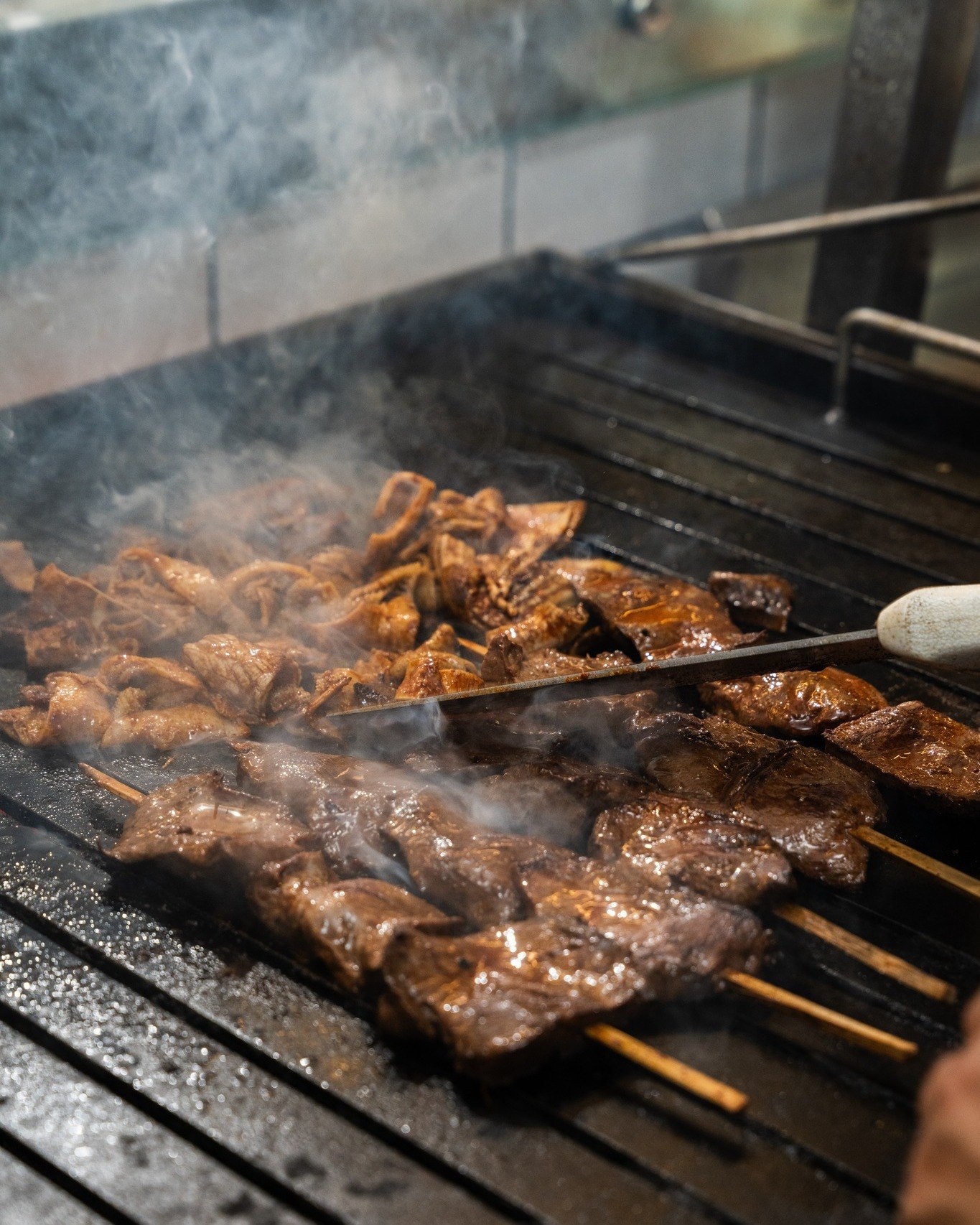 Anticuchos sobre la parrilla entre el humo en Ruperta